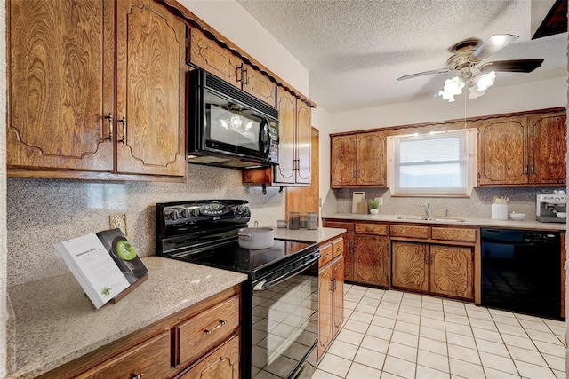 kitchen featuring a textured ceiling, ceiling fan, sink, black appliances, and light tile patterned floors