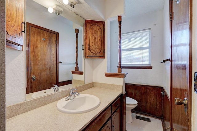 bathroom with tile patterned flooring, vanity, and toilet