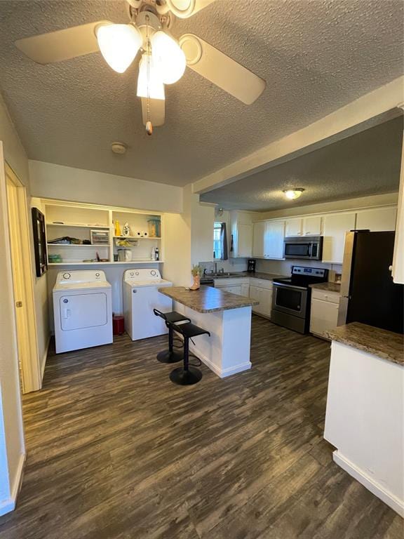 kitchen featuring appliances with stainless steel finishes, dark hardwood / wood-style flooring, a textured ceiling, ceiling fan, and white cabinetry