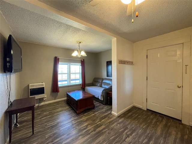 interior space with ceiling fan with notable chandelier, a textured ceiling, dark hardwood / wood-style floors, and heating unit