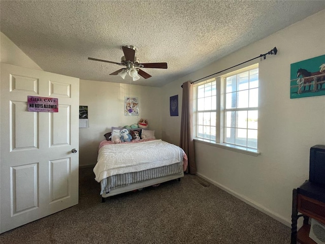 bedroom with a textured ceiling, dark carpet, and ceiling fan