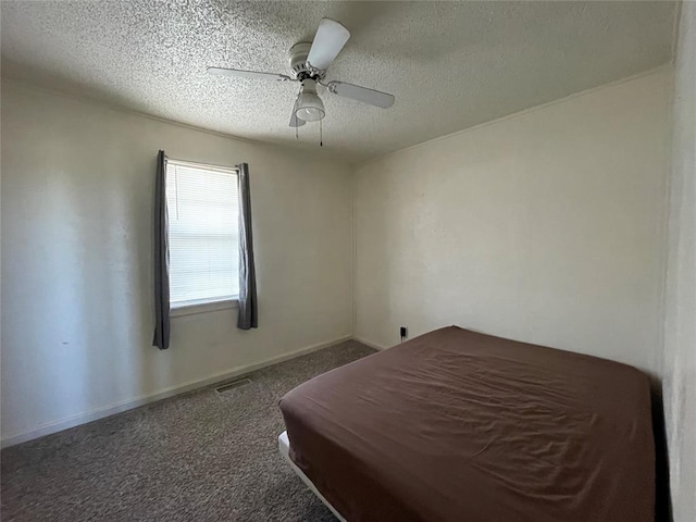 bedroom with dark colored carpet, a textured ceiling, and ceiling fan