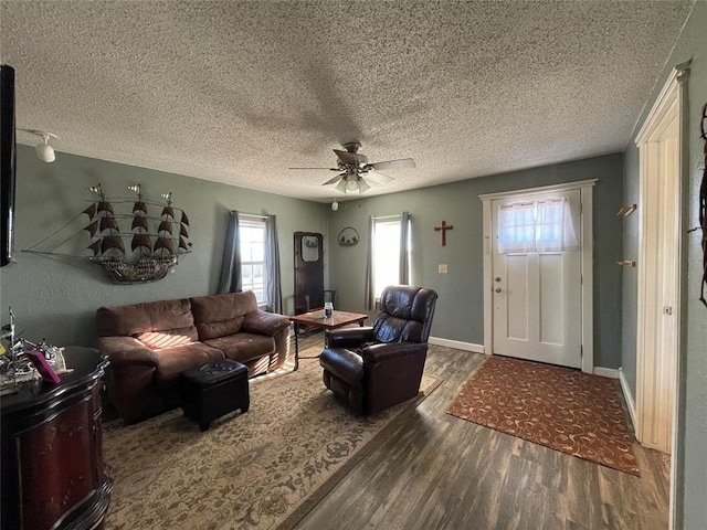 living room featuring ceiling fan, dark hardwood / wood-style flooring, and a textured ceiling