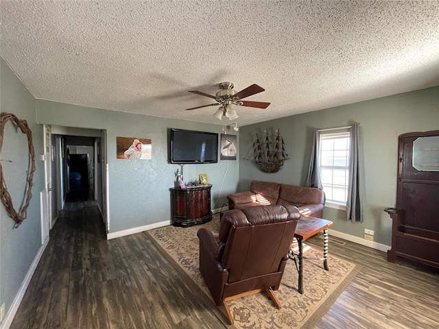 living room featuring a textured ceiling, ceiling fan, and dark wood-type flooring