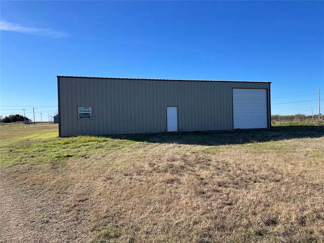 view of outbuilding featuring a lawn and a garage