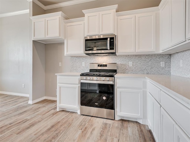 kitchen featuring crown molding, white cabinetry, stainless steel appliances, and light hardwood / wood-style flooring