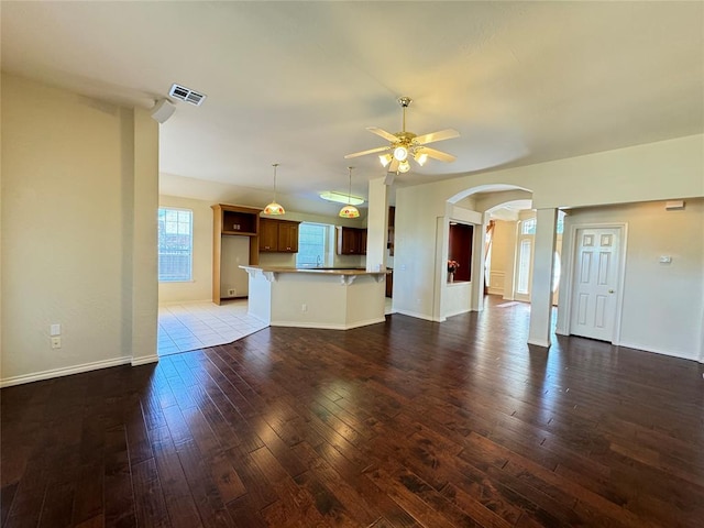 unfurnished living room with dark hardwood / wood-style floors and ceiling fan