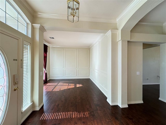 foyer entrance with dark hardwood / wood-style flooring, a chandelier, and ornamental molding