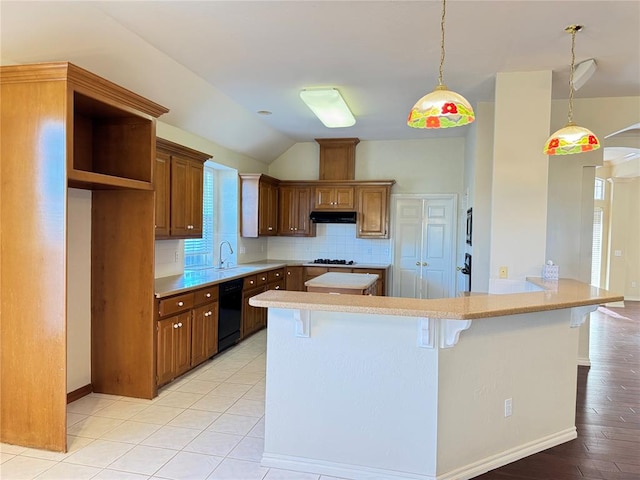 kitchen with a kitchen breakfast bar, decorative light fixtures, dishwasher, light hardwood / wood-style floors, and lofted ceiling