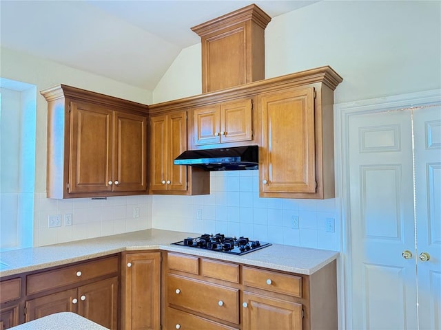 kitchen with decorative backsplash, vaulted ceiling, and black gas stovetop