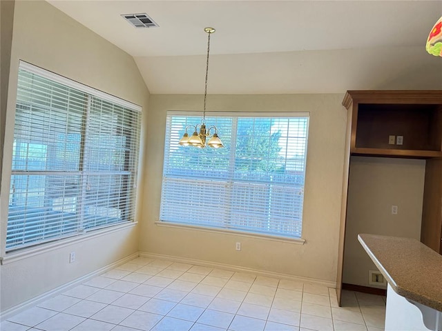 unfurnished dining area featuring a chandelier, light tile patterned floors, and vaulted ceiling