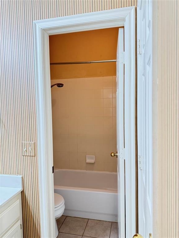 full bathroom with tile patterned floors, vanity, tiled shower / bath combo, and toilet