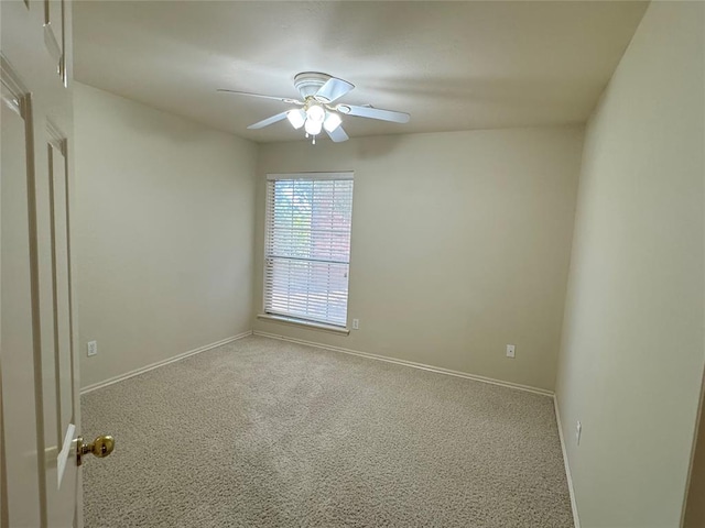 carpeted spare room featuring ceiling fan