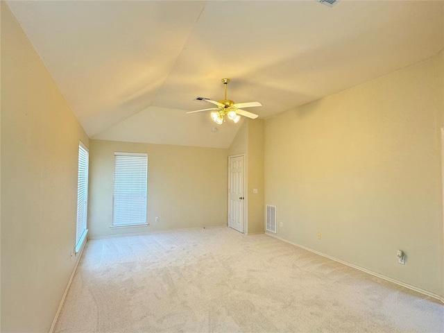 carpeted empty room with ceiling fan and vaulted ceiling