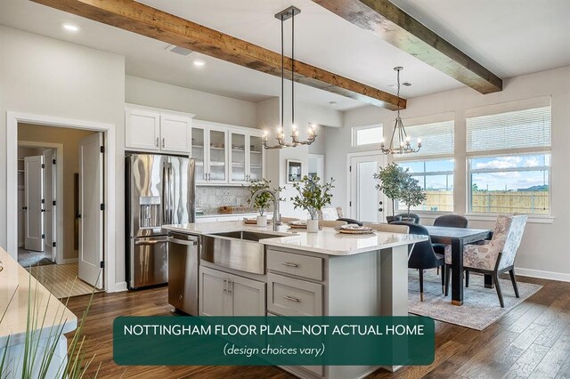 kitchen with a center island with sink, sink, hanging light fixtures, dark hardwood / wood-style floors, and stainless steel appliances