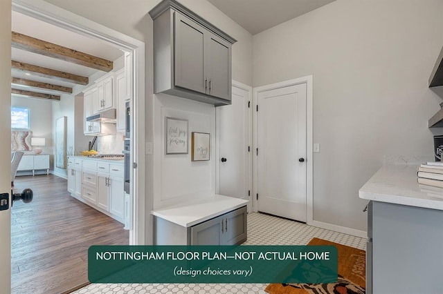 kitchen with beam ceiling, gray cabinets, and light wood-type flooring