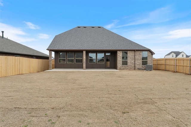 729 Caladium Dr, Yukon, OK 73099 - back of house with brick siding, a shingled roof, central air condition unit, a fenced backyard, and a patio area