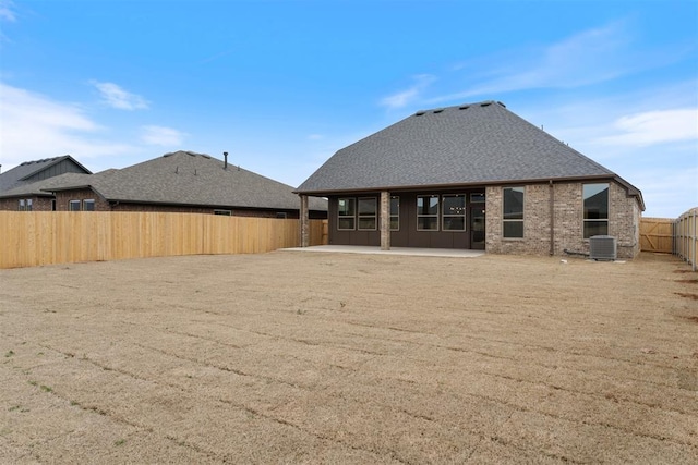 729 Caladium Dr, Yukon, OK 73099 - rear view of house featuring a fenced backyard, cooling unit, roof with shingles, brick siding, and a patio area