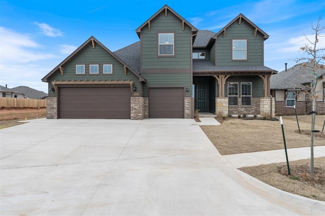 craftsman-style home with fence, driveway, covered porch, a shingled roof, and a garage