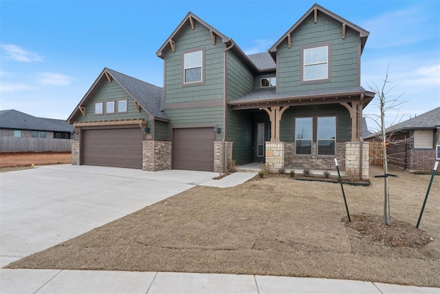 craftsman house with concrete driveway, an attached garage, fence, and covered porch