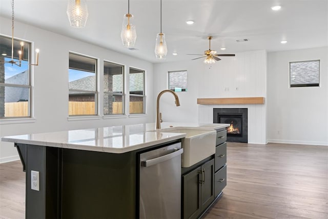 729 Caladium Dr, Yukon, OK 73099 - kitchen with stainless steel dishwasher, ceiling fan, wood finished floors, and a sink