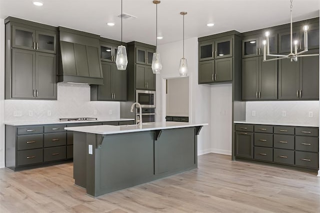 729 Caladium Dr, Yukon, OK 73099 - kitchen with custom exhaust hood, light countertops, light wood-style floors, and appliances with stainless steel finishes