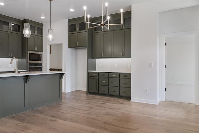 729 Caladium Dr, Yukon, OK 73099 - kitchen featuring a sink, stainless steel appliances, light countertops, a notable chandelier, and tasteful backsplash