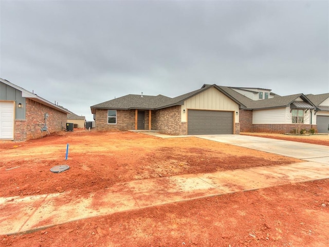 view of front of property with a garage, concrete driveway, roof with shingles, board and batten siding, and brick siding