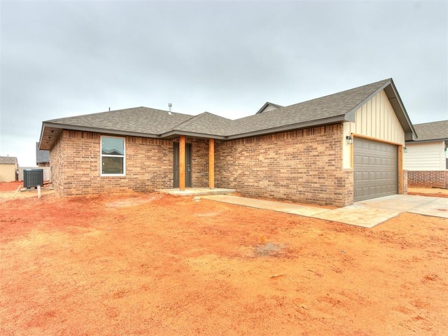 ranch-style house with a garage, concrete driveway, brick siding, and central AC