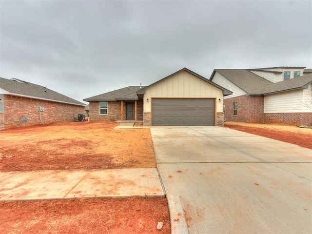 view of front of house with driveway, brick siding, board and batten siding, and an attached garage