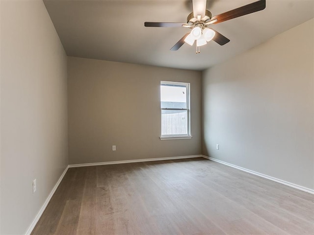 unfurnished room featuring wood finished floors, a ceiling fan, and baseboards