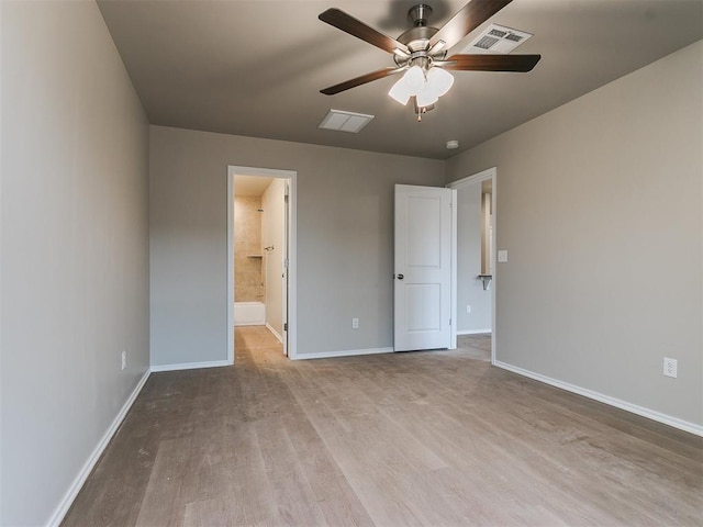 unfurnished bedroom featuring wood finished floors, visible vents, and baseboards