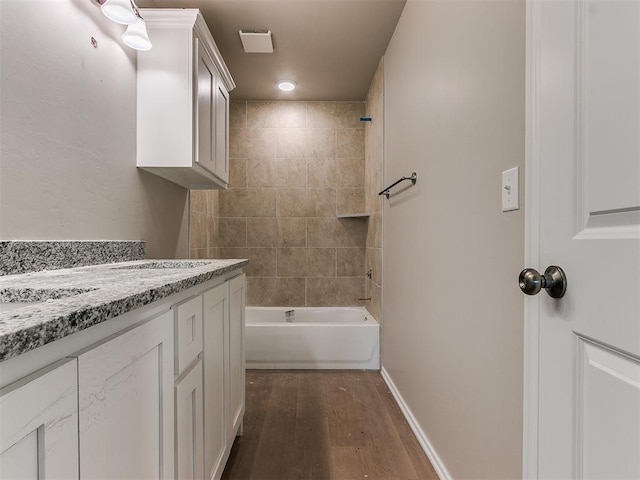 full bathroom featuring  shower combination, vanity, baseboards, and wood finished floors