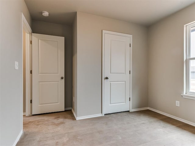 unfurnished bedroom featuring light wood-style flooring and baseboards