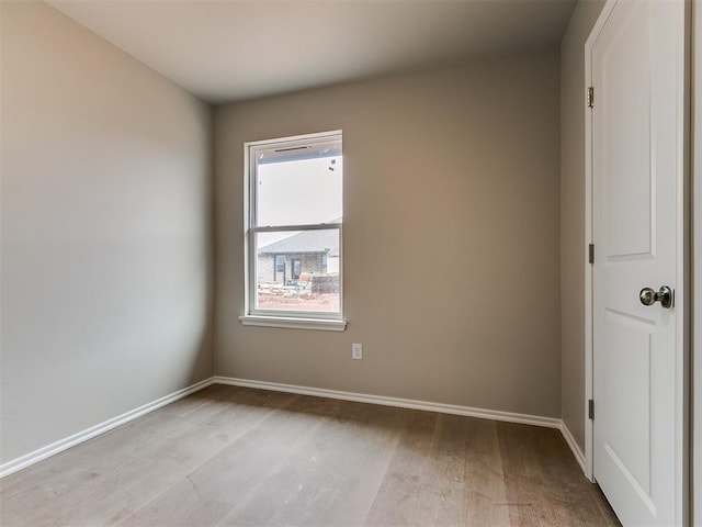 unfurnished room with baseboards and light wood-style floors