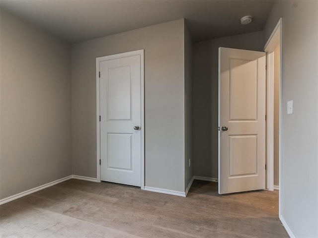 unfurnished bedroom featuring baseboards and wood finished floors