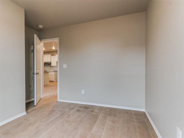 unfurnished room featuring light wood-style floors and baseboards