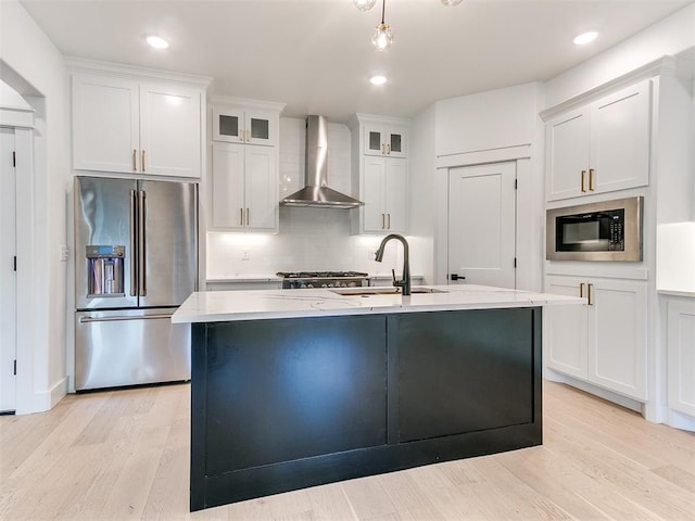 913 NW 43rd St, Oklahoma City, OK 73118 - kitchen with high quality fridge, wall chimney exhaust hood, black microwave, light wood-style flooring, and white cabinets