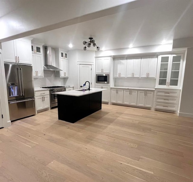 913 NW 43rd St, Oklahoma City, OK 73118 - kitchen with high end appliances, wall chimney range hood, light wood-style flooring, white cabinets, and recessed lighting