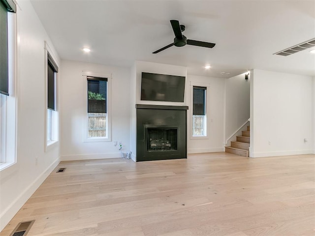 unfurnished living room featuring ceiling fan and light hardwood / wood-style flooring