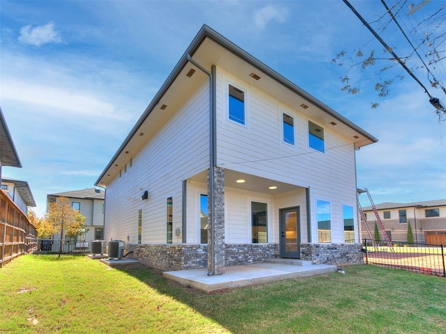 rear view of house featuring a lawn, a patio area, and central air condition unit