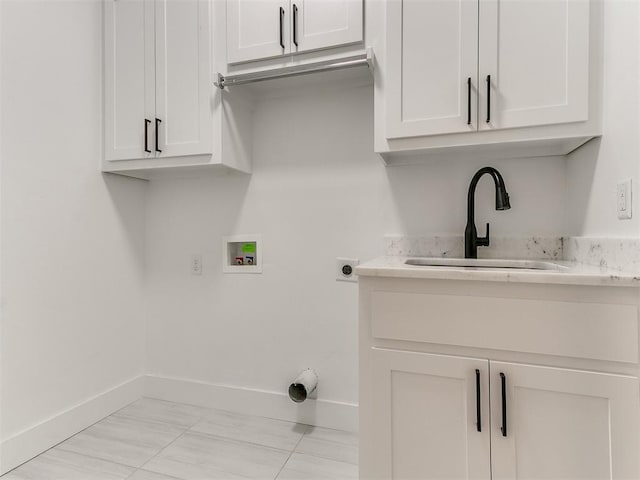 laundry area featuring hookup for an electric dryer, washer hookup, cabinets, sink, and light tile patterned floors