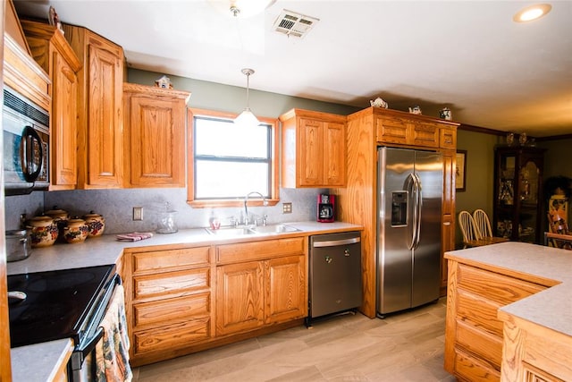 kitchen with sink, crown molding, pendant lighting, decorative backsplash, and black appliances