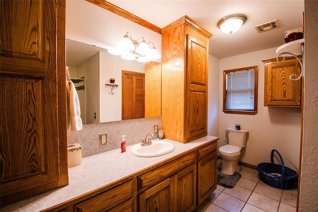 bathroom featuring tile patterned flooring, vanity, an inviting chandelier, and toilet