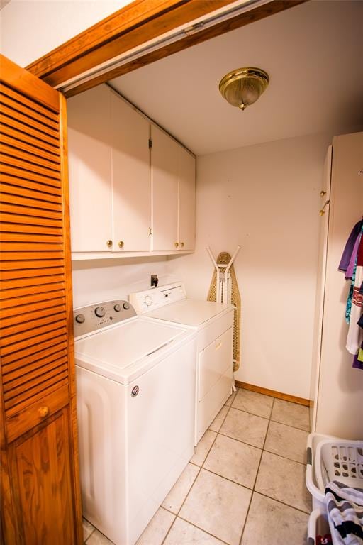 laundry room featuring cabinets, independent washer and dryer, and light tile patterned flooring