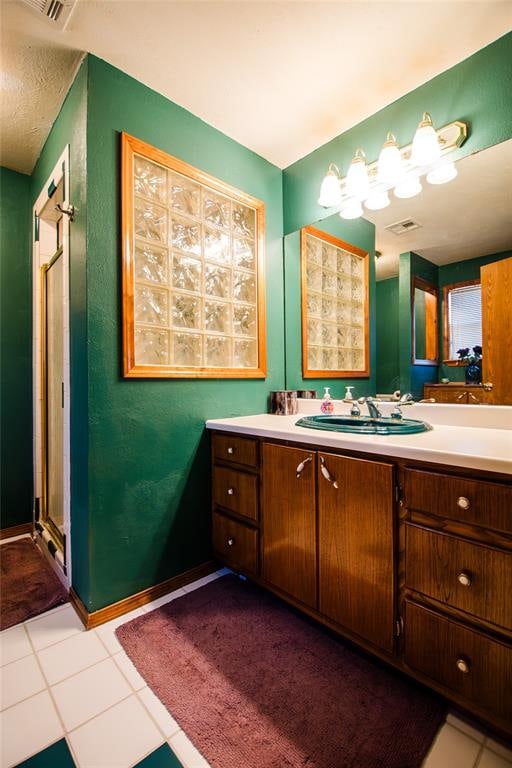 bathroom with tile patterned floors, vanity, and walk in shower