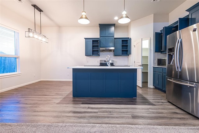 kitchen featuring pendant lighting, an island with sink, dark hardwood / wood-style flooring, stainless steel fridge with ice dispenser, and decorative backsplash