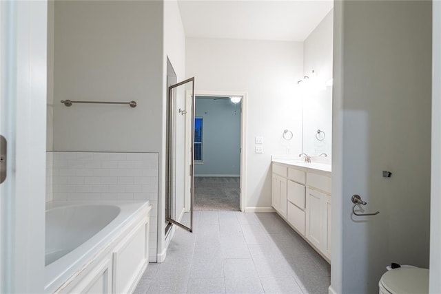 bathroom with vanity, toilet, and a tub