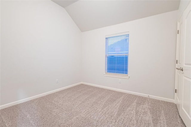 unfurnished room featuring lofted ceiling and carpet flooring