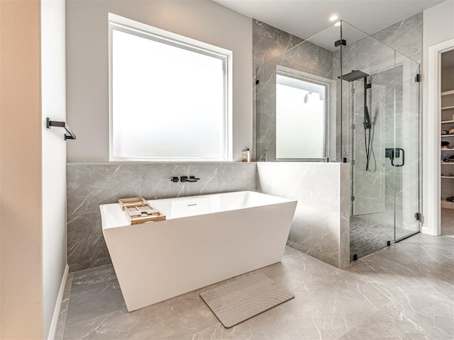 bathroom with separate shower and tub and tile walls